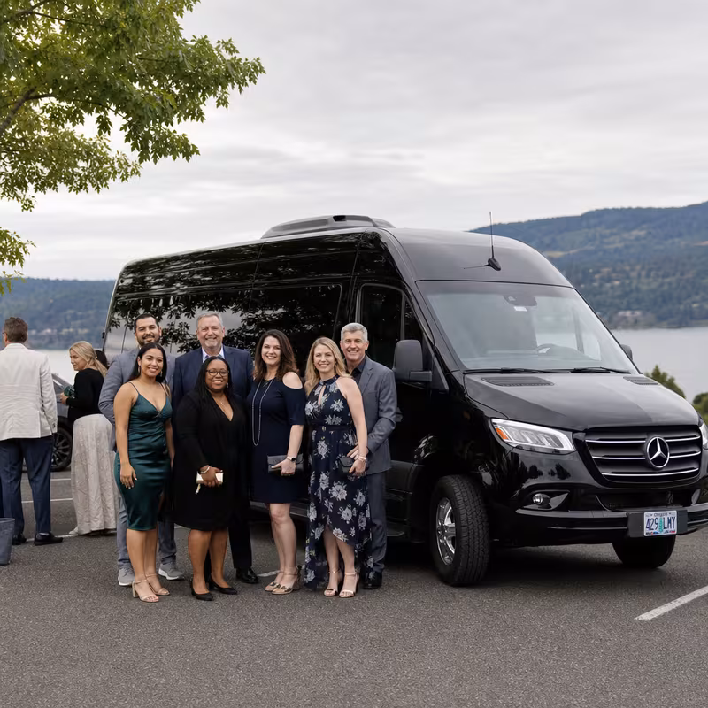 Group beside a Mercedes Sprinter limo from the Salem fleet at the beach