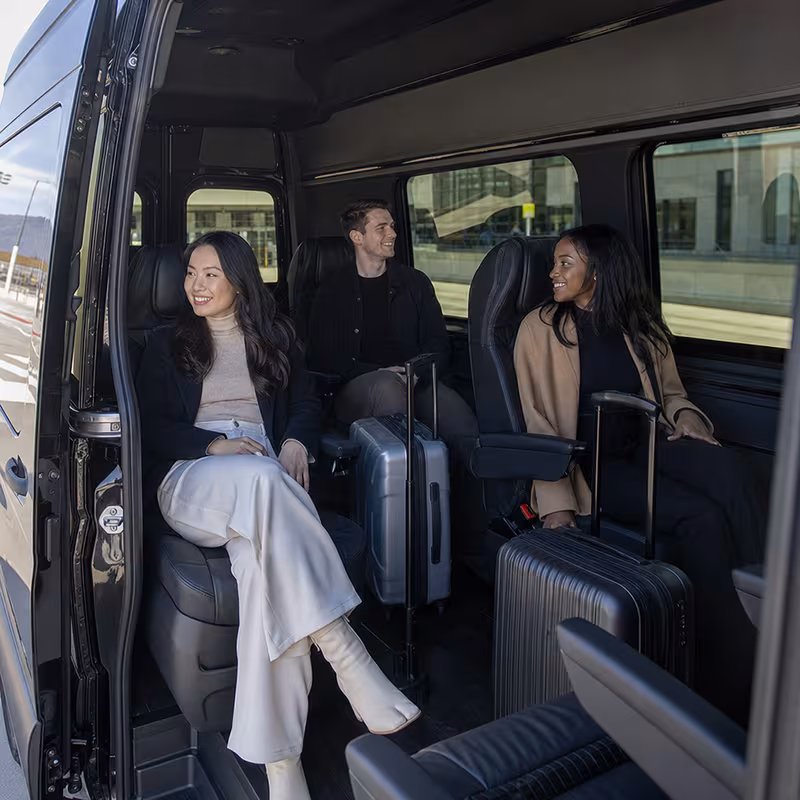Passengers loading luggage while boarding an Salem group shuttle