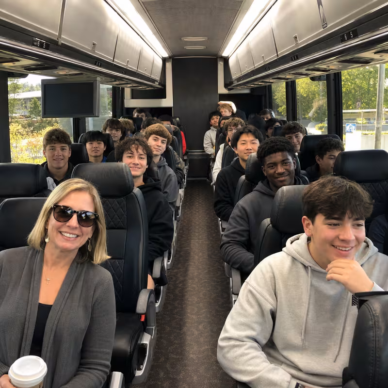 Group boarding a white charter bus for School Transportation transportation in Salem