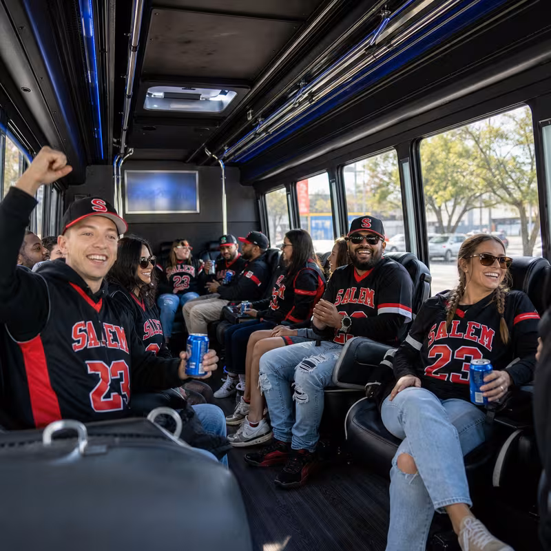 Group boarding a white charter bus for Sporting Event Transportation transportation in Salem