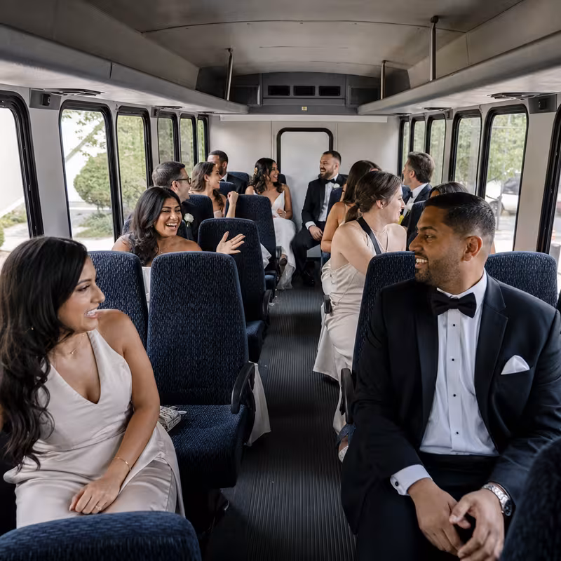 Group boarding a white charter bus for Wedding Transportation transportation in Salem